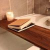 Elegant wooden bath caddy tray made of solid Walnut, adjustable to fit standard tubs, perfect for holding a book, candle, and glass of wine during a relaxing soak