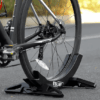 Adjustable plastic bike parking stand holding a mountain bike securely, showcasing a stable and sleek design with adjustable width for different tire sizes.