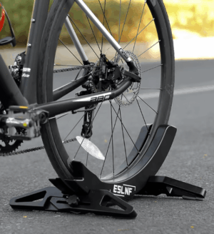 Adjustable plastic bike parking stand holding a mountain bike securely, showcasing a stable and sleek design with adjustable width for different tire sizes.