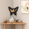 Butterfly-shaped wooden wall shelf with moon and star cutouts, mounted in a corner with decor items. 