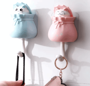 Lucky cat decorative wall hook with adhesive backing, designed for hanging keys, hats, and small items with a fun and functional design. 