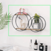 Nordic circular wall shelf in black with wooden base, holding decorative candles and plants. 
