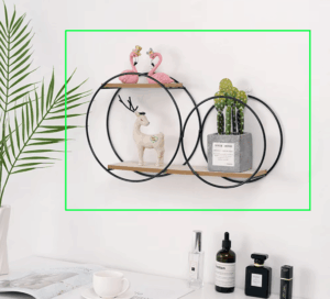 Nordic circular wall shelf in black with wooden base, holding decorative candles and plants. 